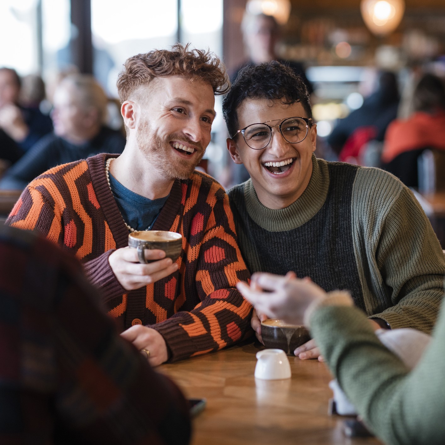 Deux hommes souriant qui prennent un café