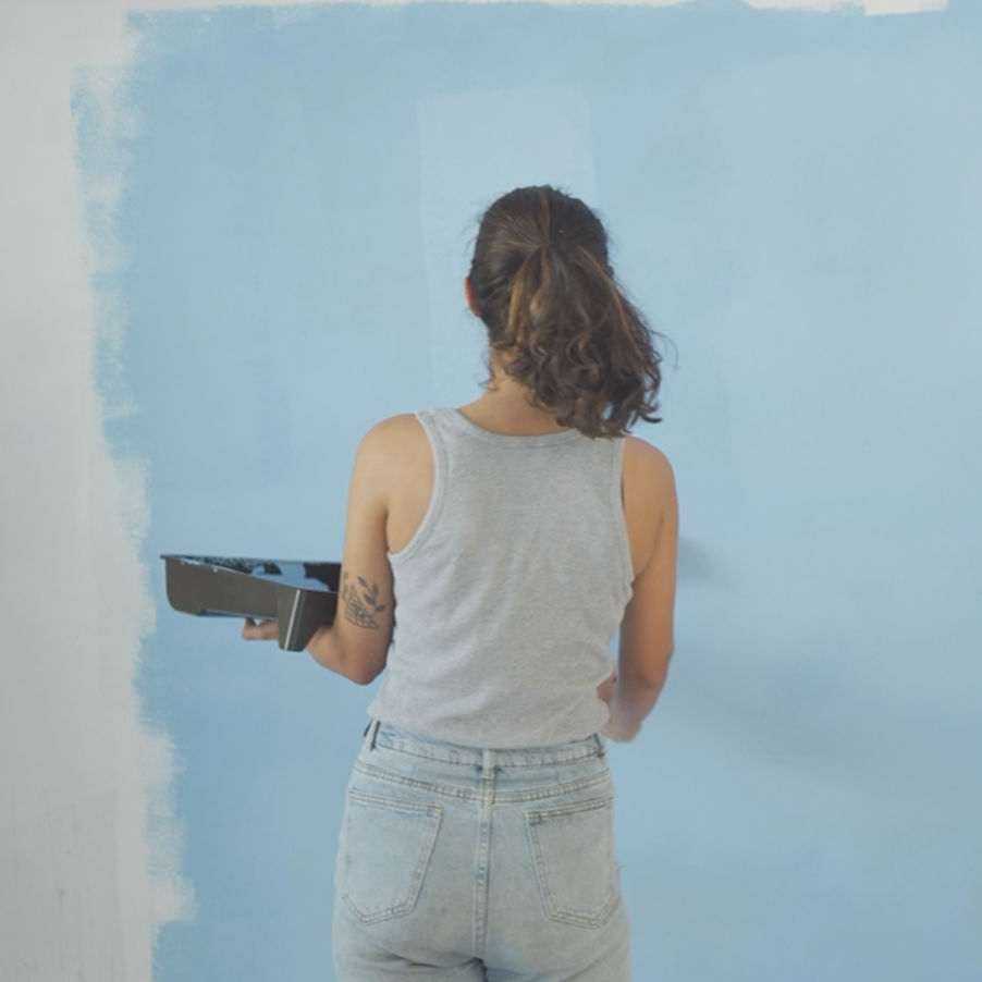 Woman painting a wall in blue